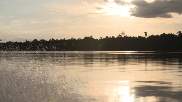 Beautiful sunset over the river next to rainforest shot from boat