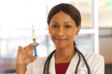 Closeup of young African doctor holding medical injection for vaccination
