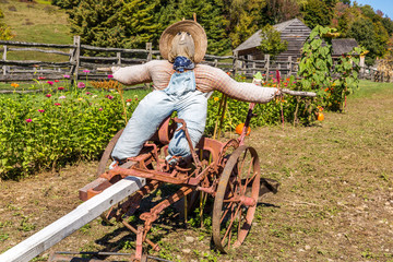 Scarecrow Resting on Farm Equipment at a Farm