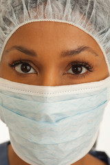 Close view of millennial African surgeons face wearing mask and hair net