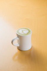 hot green tea latte on the wooden table