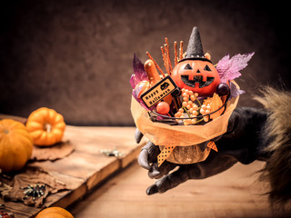 Happy Halloween. Werewolf or zombie hands making scary pumpkin gift for trick or treat party. copy...