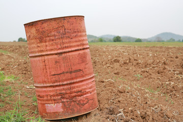 Obraz premium An old fuel tank in summer field after harvest.