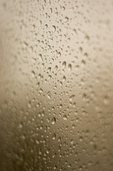 raindrops on window glass on background of cloudy sky