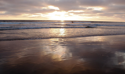 Obraz premium A southern California, USA sunset in summer with the fading sunlight shining over the shore of the Pacific ocean 