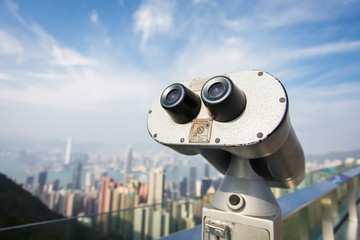 Touristic telescope look at the city of Hong Kong, close up metal binoculars on background viewpoint overlooking city