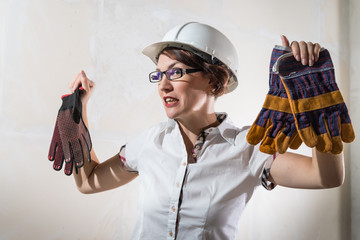 Cute young woman in white construction protection building helmet in unfinished apartment © keleny