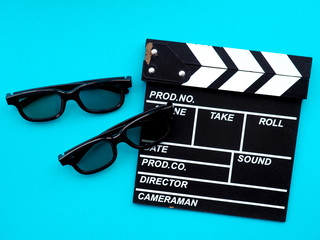 Movie clapperboard on blue background, glasses for cinema