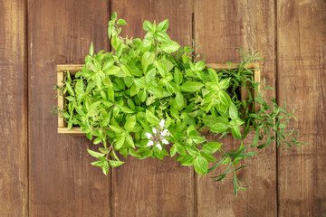 Obraz na płótnie Canvas Overhead photo of a box with aromatic garden herbs, with copy space