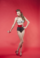 Fototapeta na wymiar portrait of girl in pin up style on red background 