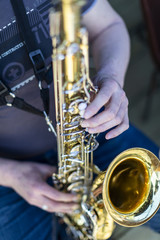 A person playing a lacquered saxophone