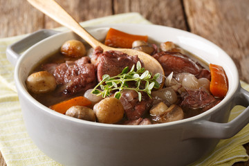 cock with wine and vegetables, thyme close-up in a pot. Coq au vin. horizontal