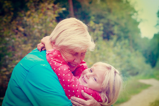 happy grandmother and granddaughter hug in nature