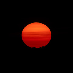 Sunrise over mountain peak with huge orange sun