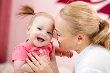 Portrait of happy mother and her baby daughter at home