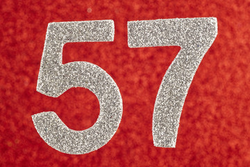 Number fifty-seven silver color over a red background. Anniversary