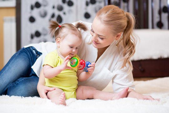 Cute Mother And Baby Girl Playing At Home