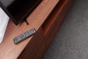 Tv and remote control on the brown wooden table