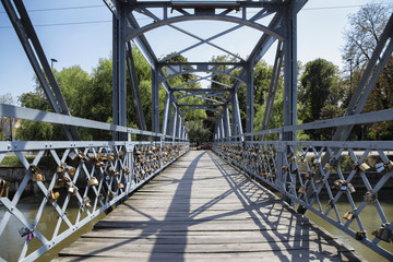 Fototapeta premium CLUJ-NAPOCA, TRANSYLVANIA, ROMANIA - AUGUST 21, 2018: Love padlocks on Elizabeta Bridge railing on Somes River on August 21, 2018 in Cluj-Napoca.
