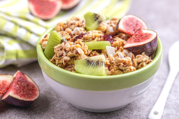 Bowl of homemade granola with fresh bananas and figs