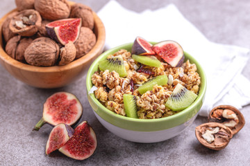 Bowl of homemade granola with fresh bananas and figs