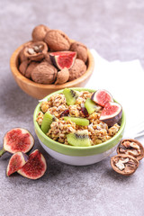 Bowl of homemade granola with fresh bananas and figs