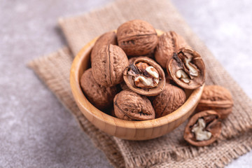 Whole walnuts in wooden bowl. Harvest concept.
