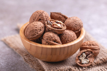 Whole walnuts in wooden bowl. Harvest concept.