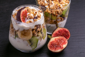 Granola with yogurt, bananas and figs. Copy space