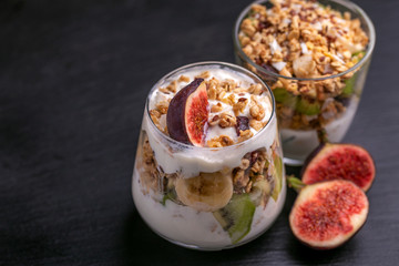 Granola with yogurt, bananas and figs. Copy space