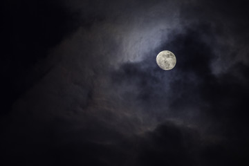 Naklejka na ściany i meble Full moon in the middle of clouds