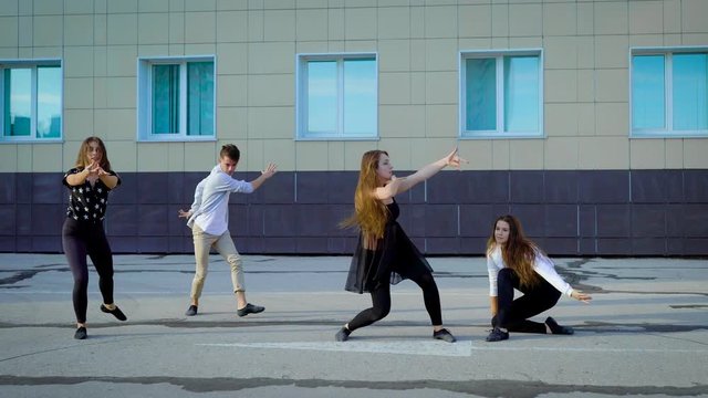Group of contemporary dancers freestyling outside in summertime.