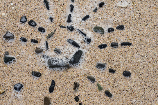 a pattern of stones on the sand near the sea