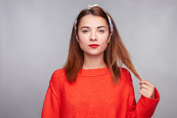 Haircut and lifestyle concept. Cute stylish red haired woman touching hair while looking deeply at...