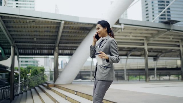 Asian business woman walking the stairs down, the modern office building background