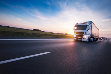 Loaded European truck on motorway in sunset - obrazy, fototapety, plakaty