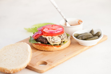 Cheeseburger with cutlet and melted cheese with pickles
