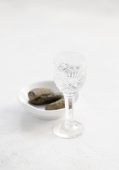 A glass of vodka and pickles on a white table