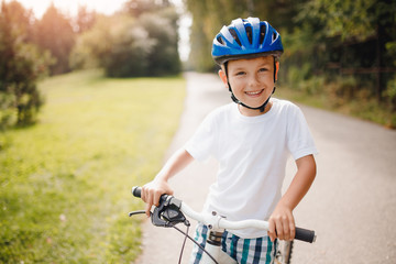 Obraz premium Little boy in helmet learning to ride bicycle park having fun