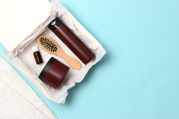 box of beauty with cosmetics for hair on a colored background top view. flatlay