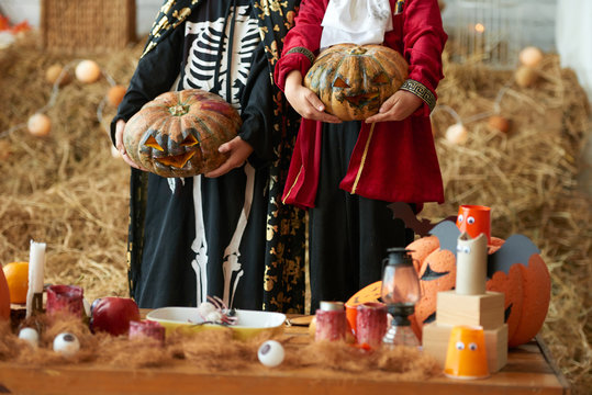 Cropped image of children holding carved pumpkins for Halloween party
