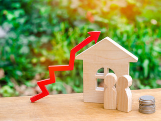 wooden house, money with a red arrow up. concept of high demand for real estate. rise in house...