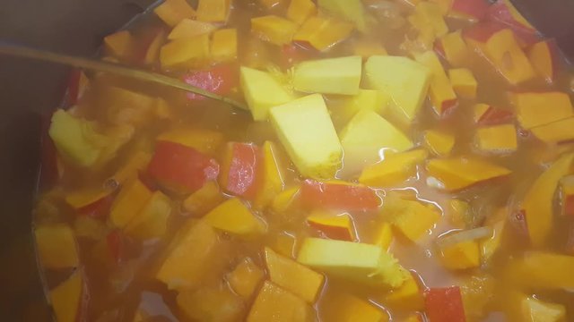 K&uuml;rbis f&uuml;r K&uuml;rbissuppe in den Topf geben