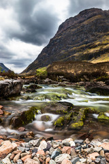 Glencoe river with smooth water flow and cloudy day. hill views at the back