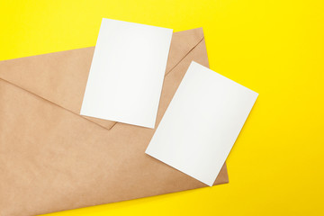 two blank postcard with brown envelope on yellow background