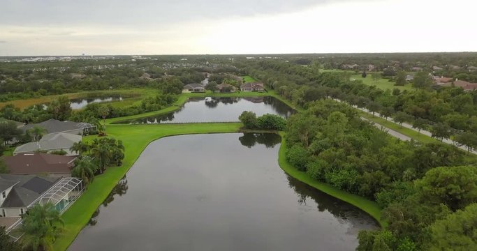 Drone moving over Sarasota town and pond