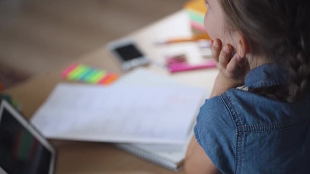 Schoolgirl in classroom, got a bad grade on test work, sad emotion.