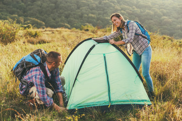 Happy couple is camping in mountain.