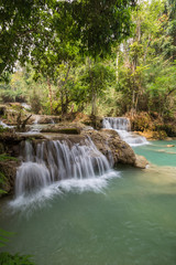 Fototapeta na wymiar Beautiful view of several small cascades at the Tat Kuang Si Waterfalls near Luang Prabang in Laos on a sunny day.