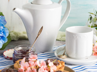 Breakfast table setting with white crockery and flowers